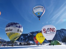 Bunte Ballons am Himmel und schnelle Sportler im Schnee